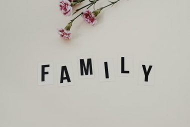 Elegant arrangement of pink flowers and family text on a white background, ideal for family themes.